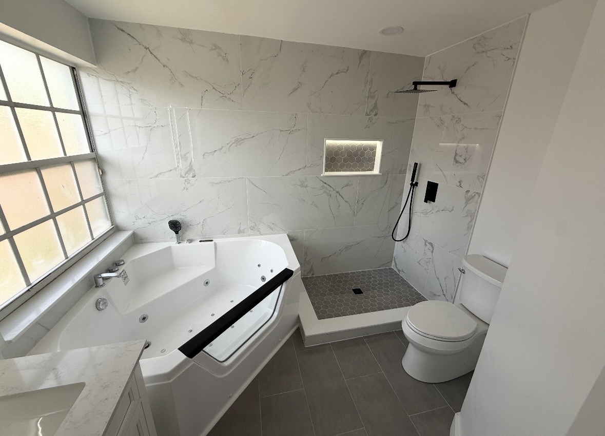 Finished bathroom with marble-look tile, walk-in shower and jetted tub